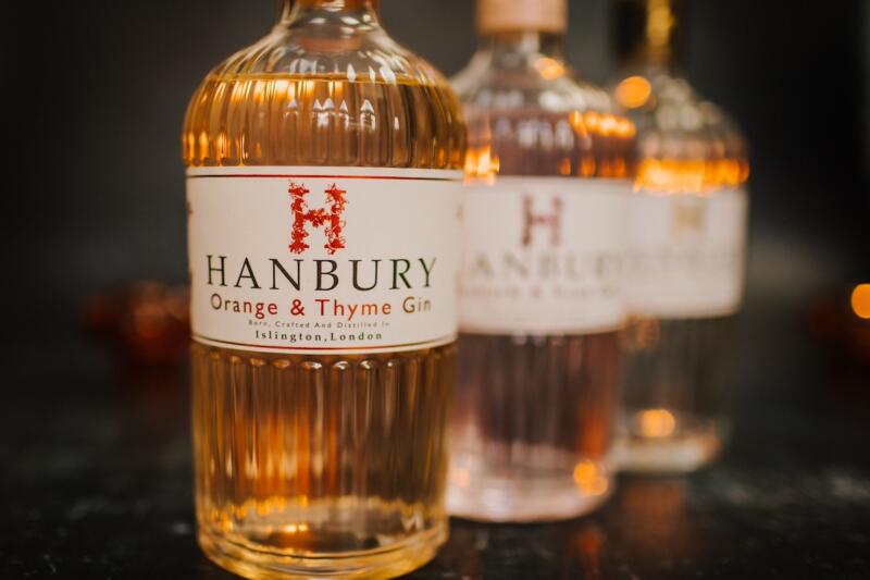 Hanbury Gin bottles lined up, with Orange & Thyme at the front