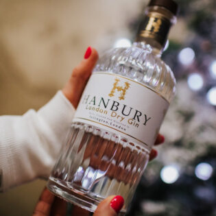 Hand holding a bottle of Hanbury gin