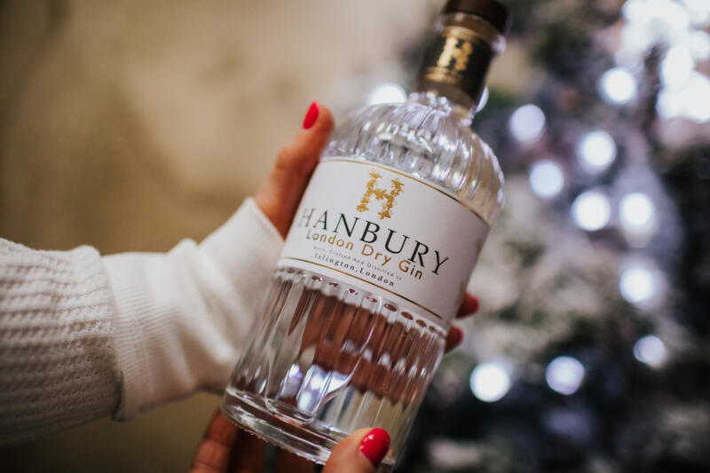 Hand holding a bottle of Hanbury gin